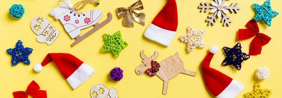 superiore Visualizza di bandiera Natale decorazioni e Santa cappelli su giallo sfondo. contento vacanza concetto foto