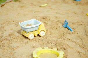 sandbox giocattoli come come camion plastica figli di giocattoli nel il sabbia, spiaggia ricreazione per bambini. foto