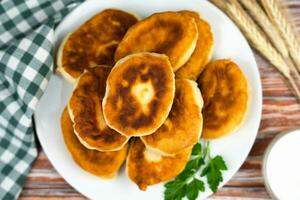 fritte fatti in casa torte con carne e patate su un' di legno tavolo a il cucina. della nonna ricetta. superiore Visualizza. avvicinamento. foto