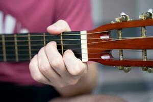 un' giovane uomo giochi il chitarra. avvicinamento. selettivo messa a fuoco. foto