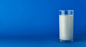 bicchiere di latte isolato su blu sfondo con copia spazio foto