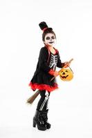 ritratto ragazza asiatica in costume di halloween in sella alla scopa con zucca