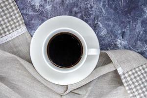 tazza bianca di caffè nero americano e un bellissimo scialle fatto foto