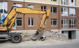 caricatore di gru mobile di colore giallo sullo sfondo di un edificio foto