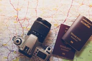 passaporto thailandese e fotocamera sulla mappa per i viaggi nel mondo foto