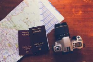 passaporto thailandese e fotocamera sulla mappa per i viaggi nel mondo foto