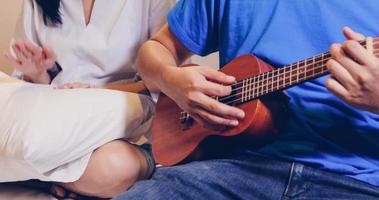 coppia che suona l'ukulele a letto foto