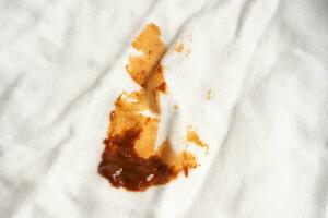 sporco salsa macchia su stoffa per lavare con lavaggio polvere, pulizia lavori di casa concetto. foto