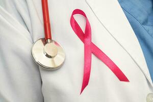 Seno cancro, asiatico medico donna con rosa nastro, simbolo di mondo Seno cancro giorno. foto