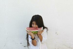 pre-teen ragazza mangiare anguria. contento infanzia. estate ragazza. foto