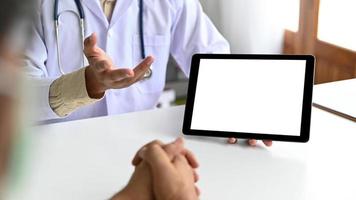 un tablet in mano al personale medico sta consultando un paziente. foto