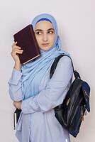 moderno musulmano alunno ragazza nel hijab. giovane medio orientale Università alunno con zaino Tenere libri e taccuini. isolato su bianca sfondo. ritratto di giovane arabo donna alunno foto