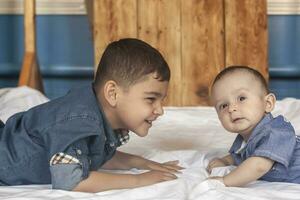 contento infanzia concetto. contento fratelli ritratto. 6 anni e 6 mesi vecchio ragazzi avendo divertimento. Due poco bambini sorridente avendo bene volta. carino poco fratelli dire bugie e giocando insieme foto