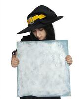 Halloween ragazza nel strega costume Tenere vuoto tavola foto