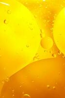 oro olio bolle vicino su. cerchi di arancia acqua macro. astratto brillante giallo sfondo foto