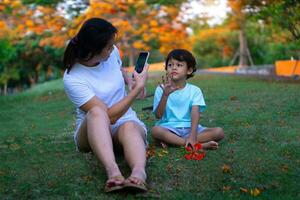 asiatico madre e figlio seduta nel il parco foto