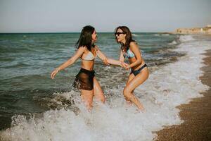 Due bella giovane donna avendo divertimento su il mare foto