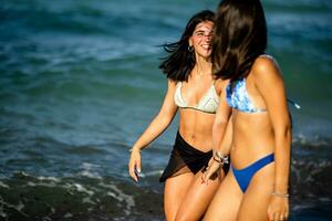 Due bella giovane donna avendo divertimento su il mare foto