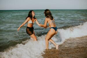 Due bella giovane donna avendo divertimento su il mare foto