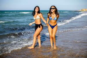 Due bella giovane donna avendo divertimento su il mare foto