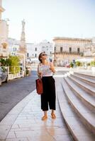 femmina turista con città carta geografica di il santo oronzo statua nel Ostuni, Italia foto