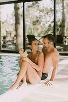 giovane coppia rilassante di il interno nuoto piscina foto