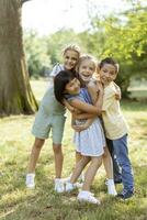 gruppo di asiatico e caucasico bambini avendo divertimento nel il parco foto