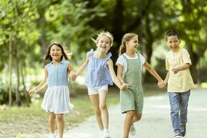 gruppo di asiatico e caucasico bambini avendo divertimento nel il parco foto