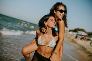 Due bella giovane donna avendo divertimento su il mare foto