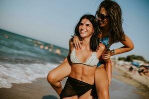 Due bella giovane donna avendo divertimento su il mare foto