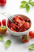 ciotola con sole secco pomodori con fresco erbe aromatiche e spezie. foto