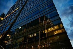 alto salire ufficio edificio con illuminato finestre a notte foto