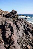 il rocce su il spiaggia siamo coperto nel nero rocce foto