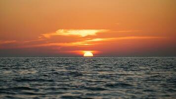 luminosa tramonto con grande giallo sole sotto il mare superficie, panorama di mare tramonto, paesaggio marino. tramonto al di sopra di il mare orizzonte foto