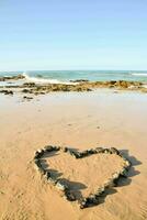 cuore fatto di rocce su il spiaggia foto