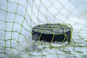 obbiettivo segnato di un' hockey disco nel il obbiettivo netto foto