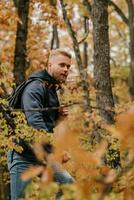 tipo turista passeggiate nel un' nebbioso autunno foresta foto