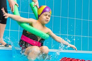 piccolo bambino nuotare nel un interno piscina. foto