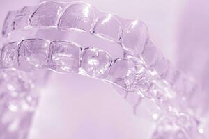 invisibile dentale denti parentesi dente allineatori su viola sfondo. plastica bretelle odontoiatria fermi per raddrizzare denti. foto