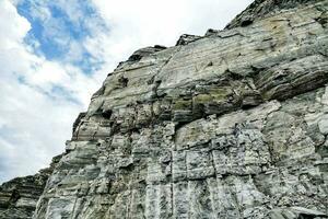 un' grande roccia viso con un' blu cielo nel il sfondo foto