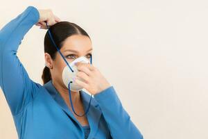 bellissimo ragazza mette su un' medico maschera su sua viso nel un' foto studio protezione contro coronavirus e covid-19