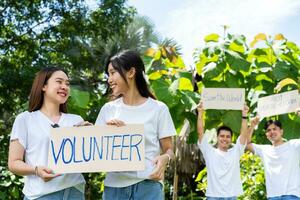 contento giovane asiatico studenti diverso volontari hold un' campagna cartello per pulizia nel il parco, il concetto di ambientale conservazione su mondo ambiente giorno, raccolta differenziata, beneficenza per sostenibilità. foto