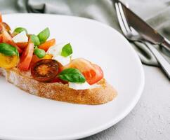 Bruschetta con pomodori, Mozzarella formaggio e basilico foto