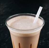 frappè nel un' plastica tazza su nero sfondo foto