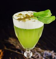 fresco basilico acida cocktail con bianca schiuma con verde basilico foglia nel un' bicchiere foto