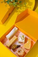 assortito torta fette nel giallo regalo scatola su giallo sfondo foto