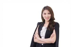 giovane bellissimo asiatico professionale donna d'affari in piedi con attraversato braccia nel ufficio spazio di lavoro mentre guardare a telecamera mentre isolato su bianca sfondo. foto