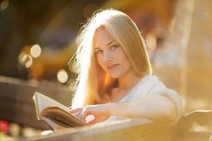 bella donna seduta e leggendo un libro foto