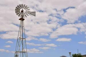 un' mulino a vento su un' collina con un' blu cielo foto