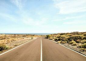 un vuoto strada principale per il oceano foto